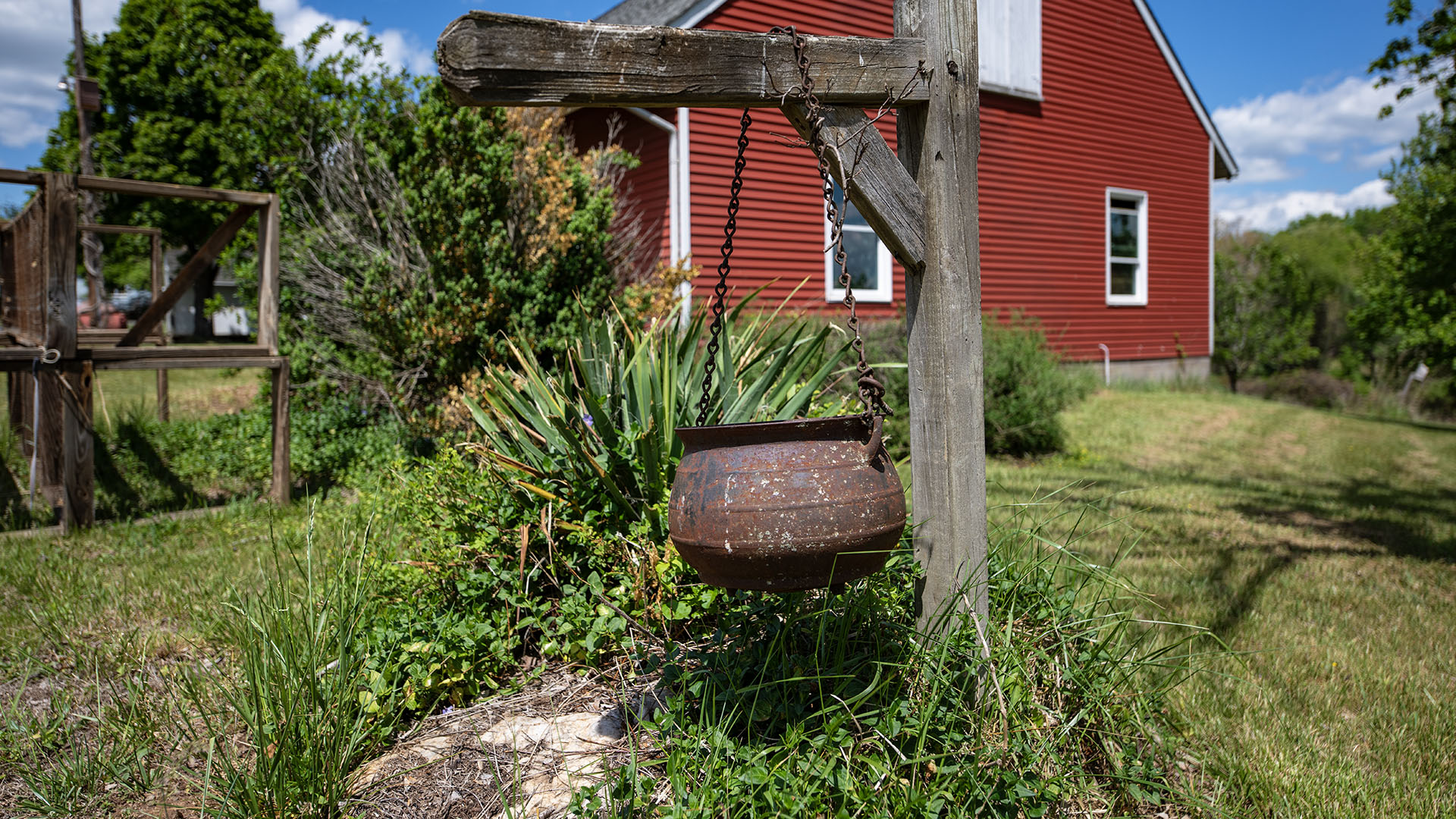 Garden detail with hanging iron kettle near the red barn at Asgardd Farm in Albemarle County VA