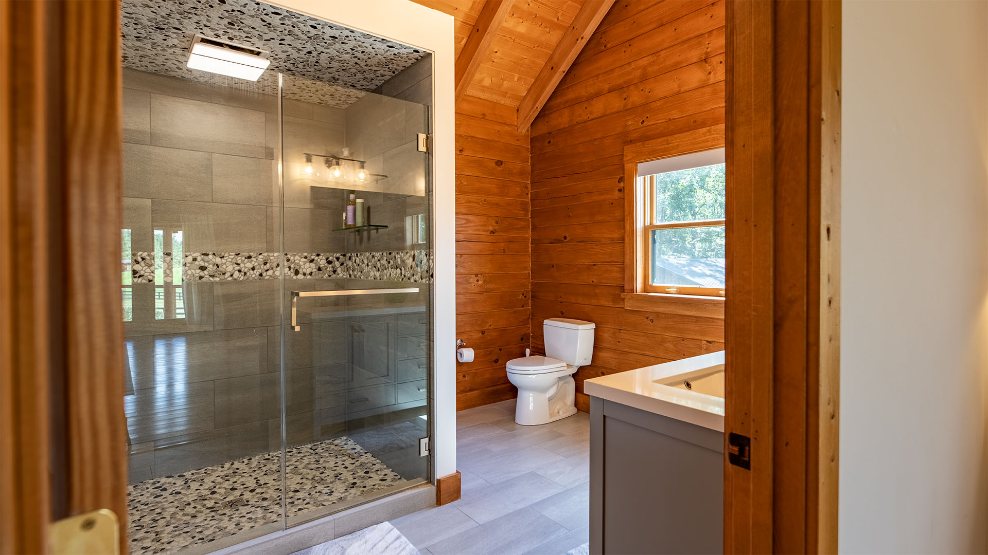 Renovated primary bathroom with large glassed-in shower in the Madison Virginia log home
